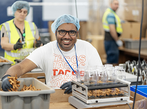 Man in hair net, sorting in factory