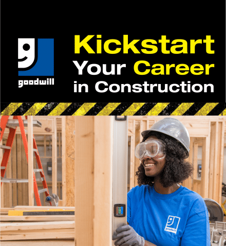 A woman wearing a hard hat and safety goggles holds a level tool at a construction site. She's smiling and wearing a blue Goodwill shirt. The top text reads, "Kickstart Your Career in Construction" next to the Goodwill logo.