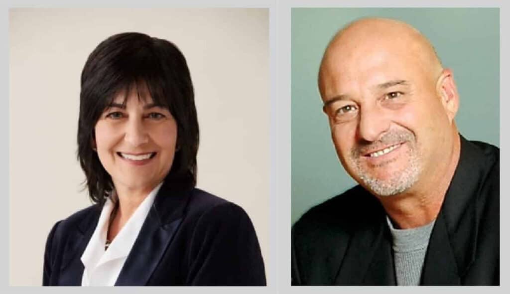 A woman with dark hair in a blue blazer smiles confidently, while a man with a shaved head and beard in a black suit poses with a friendly expression. They are positioned side by side against neutral backgrounds.